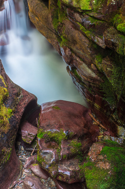 长时间曝光的照片模糊了水流穿过冰川国家公园苔藓覆盖岩石狭谷的运动。图片下载