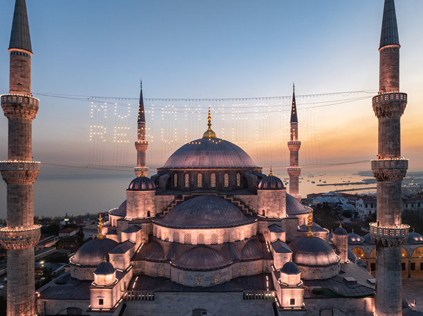 蓝色清真寺（苏丹艾哈迈德清真寺）在拉马丹月期间的灯光字母（马赫亚）悬挂在尖塔之间的无人机照片，伊斯坦布尔法提赫的苏丹艾哈迈德广场图片下载