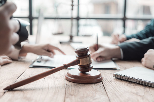 男性律师在法庭上与合同文件和木槌一起工作，展现法律与正义，律师或法官穿着西装，处理文件的特写照片。图片下载