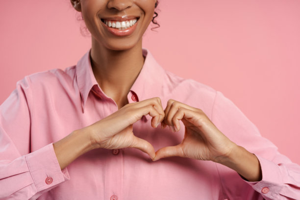 特写肖像照片，快乐迷人的女性用双手做出心形手势图片下载