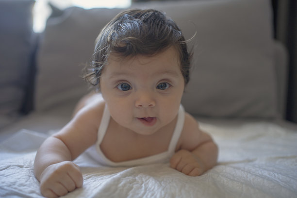 一张可爱的婴儿躺在床上的照片图片下载