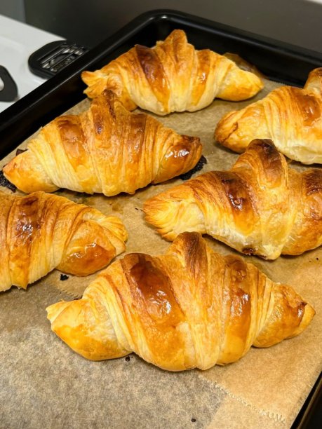 新鲜出炉的可颂面包，背景为白色。单个法式糕点特写照片。涂黄油的可颂面包，背景为白色。新鲜的可颂面包独立展示。图片下载