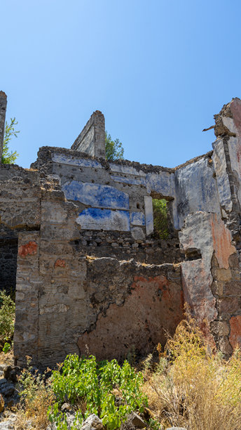 被毁坏的房屋墙壁，装饰着蓝色灰泥，位于土耳其穆拉省费特希耶市的废弃小镇或村庄凯亚库伊。竖版图片图片下载