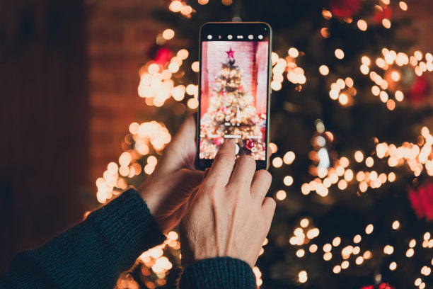 裁剪的照片，展示了一位可爱的老年女性穿着圣诞服装，享受温馨的圣诞派对装饰，室内公寓环境。图片下载