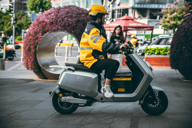 一名在中国深圳的外卖司机骑着电动车，将网上订购的食物送给顾客。图片下载