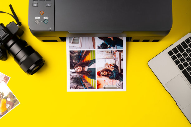 打印机在黄色背景下打印人像的彩色照片特写图片下载
