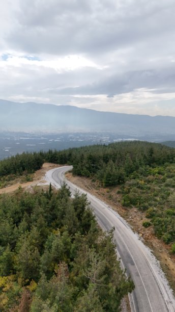 阴天的垂直航拍照片，山峰上的沥青道路。图片下载