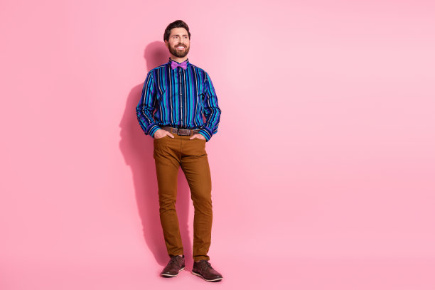 优雅的男士穿着时尚服装的全身照片，背景为粉色空白空间。图片下载