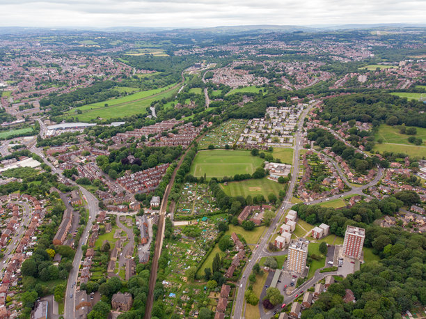 俯瞰英国西约克郡利兹的海丁利地区的航拍照片，展示了典型的英国住宅区，周围有田野和道路，拍摄于阳光明媚的日子。图片下载