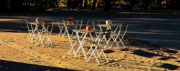 户外咖啡馆的桌椅。温暖的秋季傍晚。全景照片。选择性对焦。图片下载