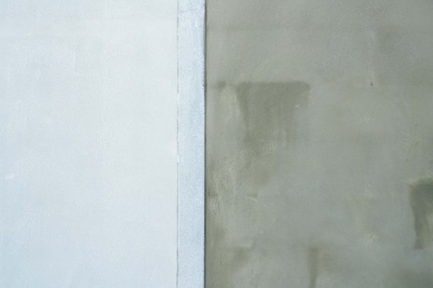 水泥墙刚刚抹好灰，开始上漆，背景和纹理的库存照片。图片下载