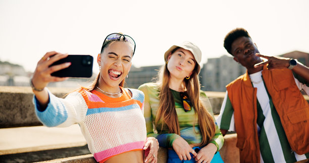 户外，朋友们搞怪自拍，夏日回忆和社交媒体头像。城市桥梁，男女拍照，展现Z世代时尚，吐舌或撅嘴，做出和平手势。图片下载
