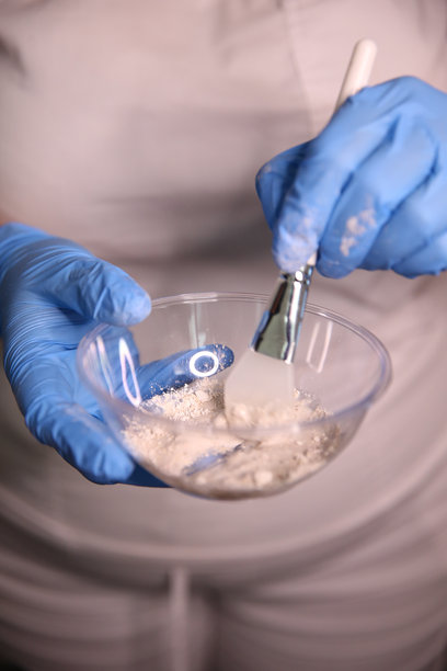 美容师正在面膜上涂抹面霜。面部卫生、化妆程序、护肤、清洁毛孔、水疗、硬件美容的概念。库存照片图片下载