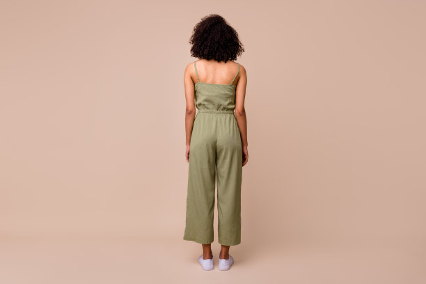 全身背影照片，棕发女性穿着工装靴，背景为米色。图片下载