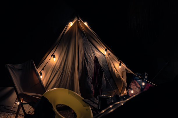 美丽、维护良好的夜间露营地。帐篷上挂着灯笼，浪漫的氛围。现代豪华露营的夜间照片。图片下载