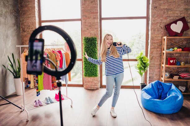 积极可爱的女孩博主在室内直播工作室唱歌、跳舞并录制生活方式内容的照片图片下载