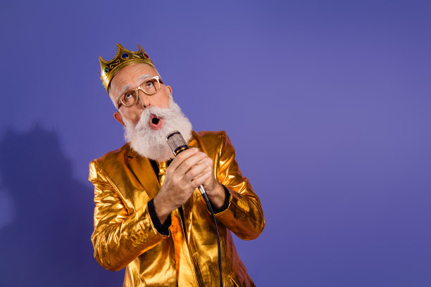 穿着时尚金色衣服的胡子绅士在紫色背景下快乐地唱歌的照片肖像图片下载