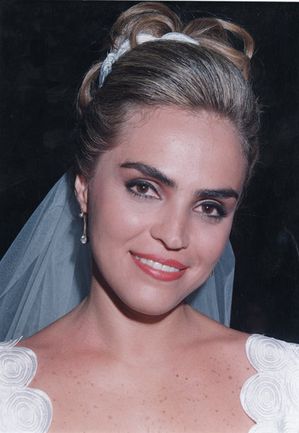 1980年代拍摄的照片：微笑的西班牙裔年轻新娘坐着摆姿势，注视着镜头图片下载