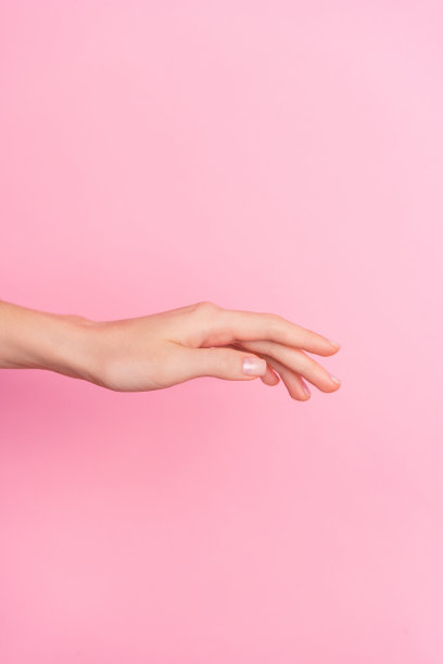 女人手掌抬起，空白区域，背景为粉色的特写照片图片下载