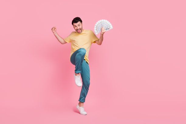 成功的幸运男人在粉色背景上庆祝赢得电子竞技职业晋升的全身照片，周围空旷。图片下载