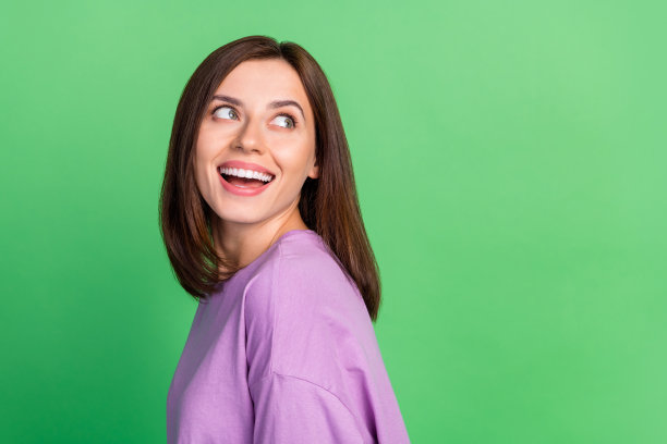 美丽女士的照片，展现闪亮的好莱坞微笑，空白空间用于牙科护理横幅，背景为绿色。图片下载