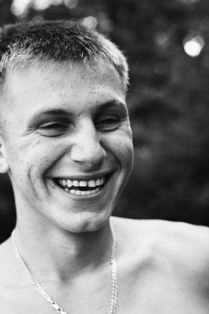 黑白照片中的男孩，快乐微笑的青少年肖像，表现出满足和喜悦的情感图片下载