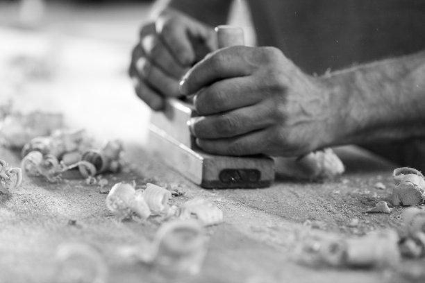 黑白照片，木匠正在使用手动刨子加工木材图片下载