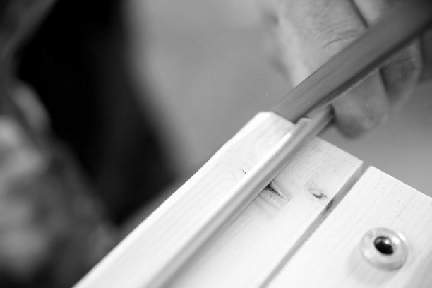 黑白照片中，木匠正在小心地加工木材图片下载