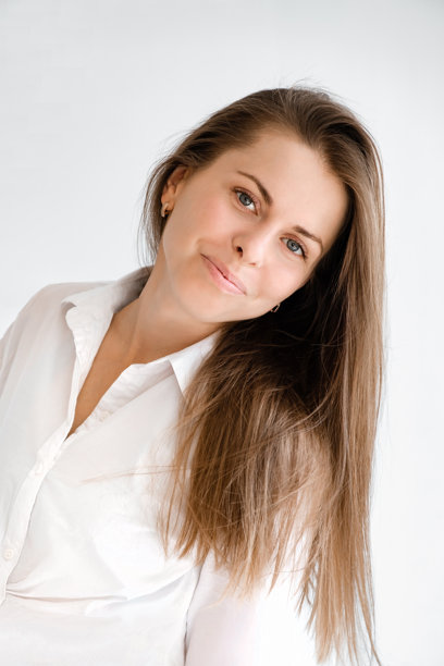 年轻微笑、自信的女性商务人士，穿着白色衬衫和休闲服，面对镜头，背景为灰色，肖像拍摄。竖版照片。生活方式概念。专业办公室工作人员。图片下载