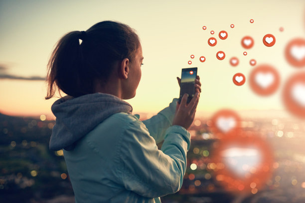 社交媒体表情符号，日落或女性拍摄风景的照片，适用于摄影内容或在线帖子。自然，图标叠加或女孩在移动应用、网站或网络上使用爱心、点赞或心形表情符号。图片下载