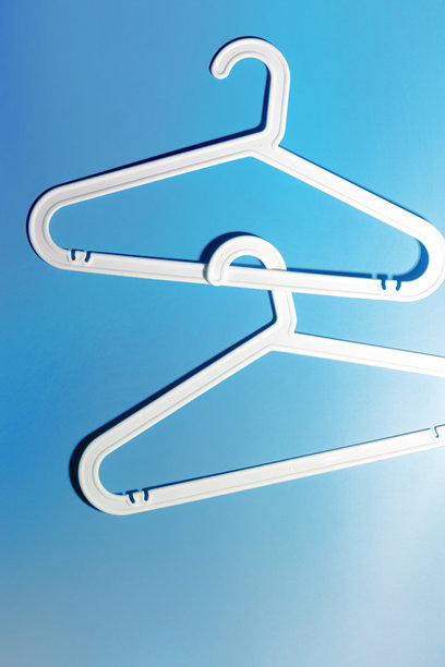 两个白色衣架，现代简约构图，背景为鲜艳的蓝色渐变，塑料架营造出现代简约的美感，俯视图，平铺创意照片，留白空间图片下载