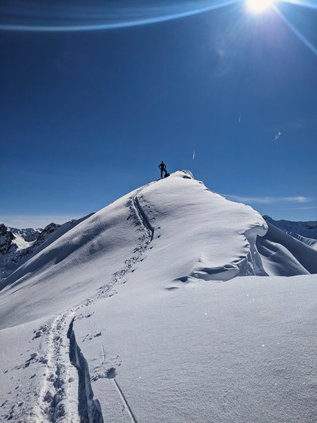 在蒙斯坦达沃斯的belenhorn山进行野外滑雪之旅。滑雪登山到一个美丽的山峰，可以看到雪山的美景。瑞士的Skitour。高质量照片图片下载