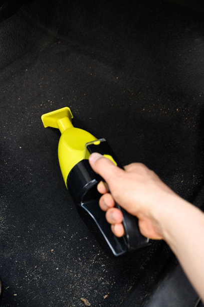 汽车清洗工为汽车清洁地毯地面，去除污垢、沙子和灰尘。关心汽车内饰，保持车内清洁。清洁概念，清洁公司。竖版图片下载