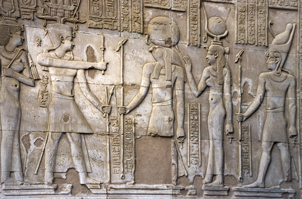 扫描的历史彩色照片，展示了埃及卡尔纳克神庙墙壁上浮雕般的法老和神祇雕刻。图片下载