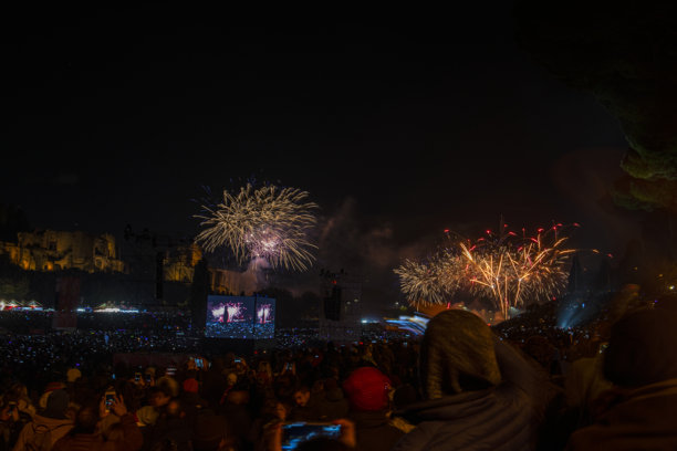 罗马广场的新年夜庆祝活动。夜间照片，烟花绽放，众多手持手机拍摄烟花的人群。罗马，意大利。图片下载