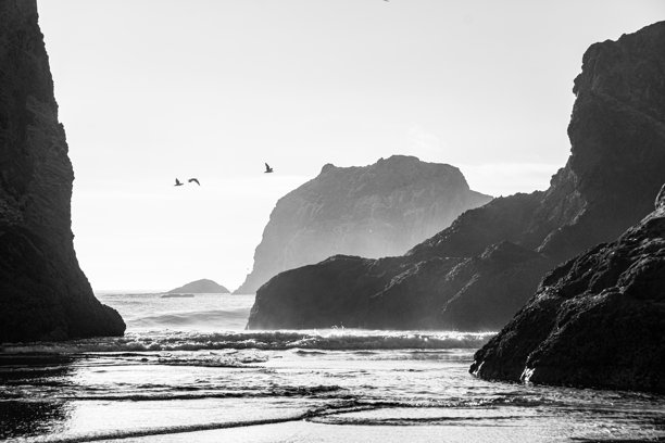 一张在俄勒冈州班登海滩拍摄的长时间曝光黑白照片，天空多云。长时间曝光模糊了海浪的运动。图片下载