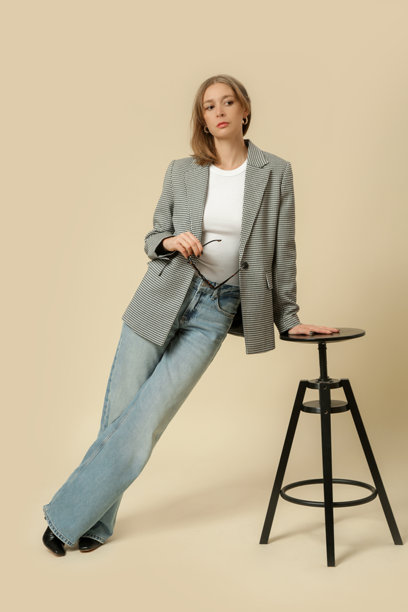 一系列女性穿着经典服装的工作室照片，白衬衫、格纹西装外套和蓝色牛仔裤。图片下载