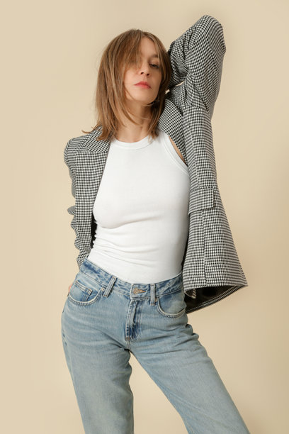 一系列女性穿着经典服装的工作室照片，白衬衫、格纹西装外套和蓝色牛仔裤。图片下载