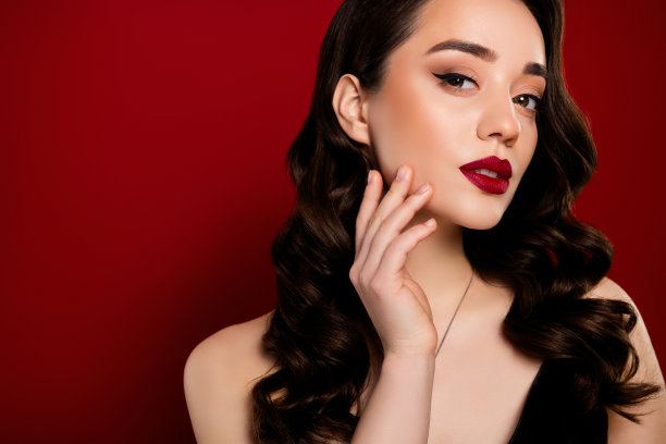 迷人且吸引人的女明星在红色背景上宣传化妆品的照片图片下载