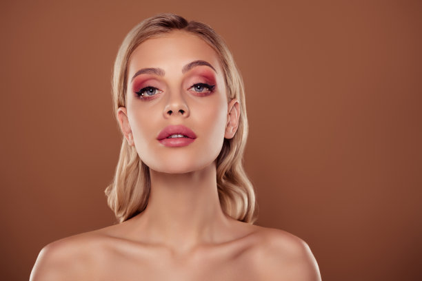 女孩在粉色眼影妆容下的照片，背景为柔和的棕色。图片下载