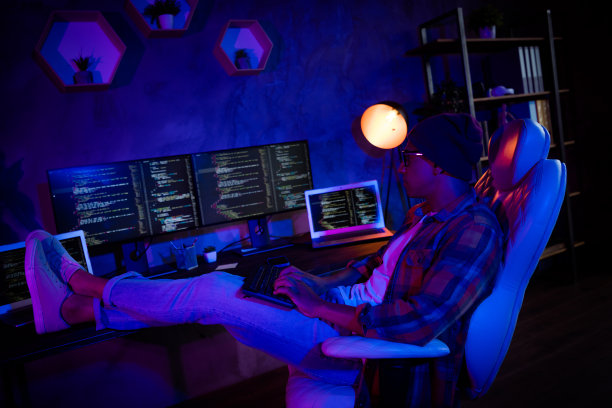 专业交易员坐在椅子上，使用键盘调试，深夜在办公室室内工作的大尺寸侧面照片图片下载