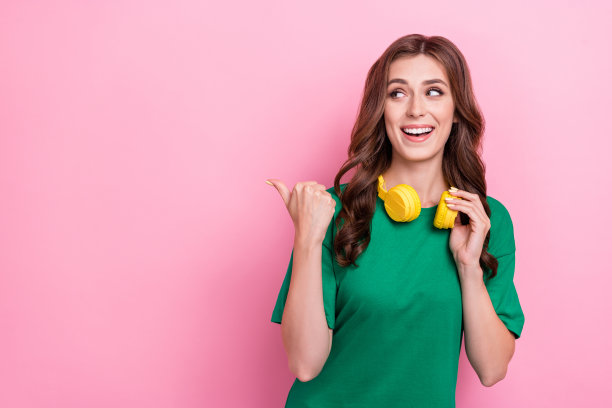 特写照片，快乐的女士穿着时尚服装，手臂指向空旷的地方，展示低价商店，背景为粉色。图片下载