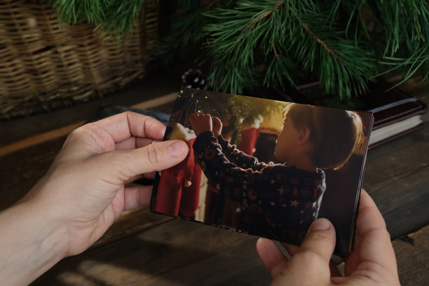 女人在翻阅打印的圣诞照片，为家庭相册整理。图片下载