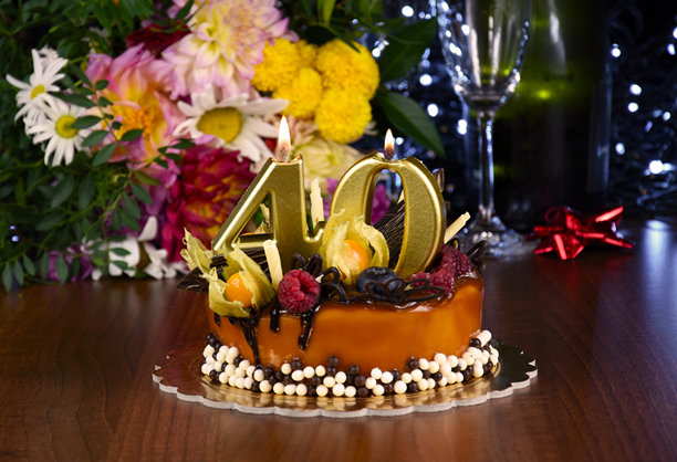 焦糖生日蛋糕，上面插着四十根蜡烛的照片图片下载