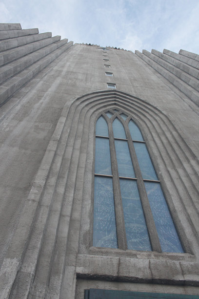 一张近距离拍摄的雷克雅未克哈尔格林姆斯教堂正面外观照片，仰望天空。图片下载