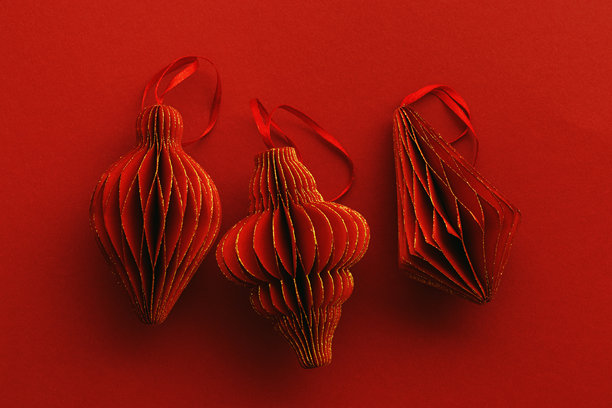 节日红色纸质圣诞装饰品，悬挂的红色手电筒，金色光辉的灯笼，红色背景上的极简美学单色照片，节日假日俯视平铺图案，留白空间图片下载