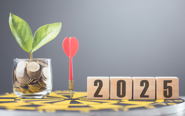 2025写在一个放置在黄色飞镖盘上的木块上，背景是柔和的灰色。这幅图象征着未来目标、规划和为即将到来的一年设定目标。图片下载