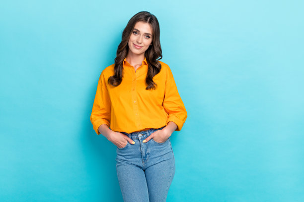 漂亮年轻女性的购物照片肖像，穿着时尚的黄色休闲服装，背景为蓝色，适合促销横幅使用。图片下载