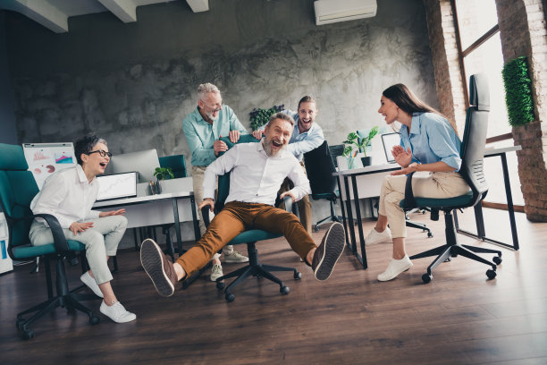 全景照片，展示了在明亮的办公室中，团队成员们愉快地坐在扶手椅上，共同进行协作项目会议，气氛成功而融洽。图片下载