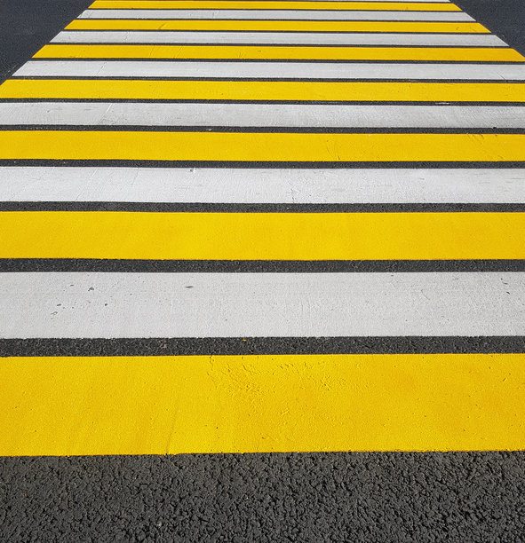 新刷的行人过街道，黄白相间的标记在沥青上，竖版照片，阳光照射图片下载